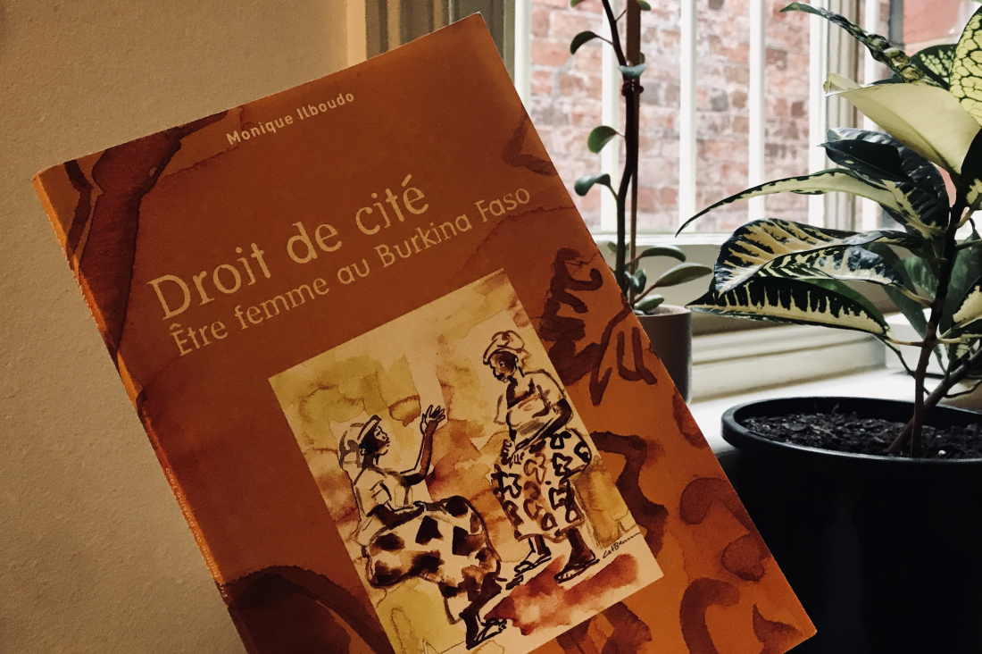 orange book with two women chatting on cover, plants in background