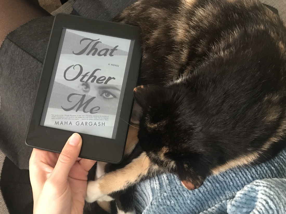 book cover with eye watching, next to cat on lap