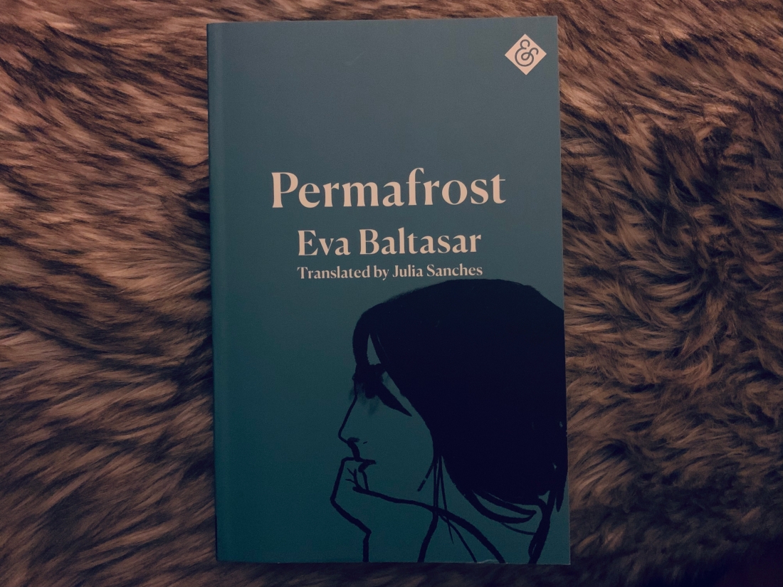 blue cover with woman resting head on hand, lying against furry blanket